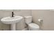 A powder room featuring a pedestal sink, toilet, and neutral wall paint at 6622 Palm Branch St, North Las Vegas, NV 89086