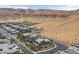 An aerial view showing the neighborhood of desert homes near mountains with landscaping, pools, and modern architecture at 6690 Interstellar St, Las Vegas, NV 89135