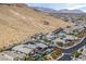 A modern home with desert landscaping and solar panels is featured in an aerial view near a desert mountain at 6690 Interstellar St, Las Vegas, NV 89135