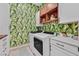 Cheerful laundry room with tropical wallpaper, white cabinetry, and front load washer and dryer at 6690 Interstellar St, Las Vegas, NV 89135