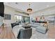 Bright living room boasts a large sectional sofa and sliding glass doors that lead to an outdoor seating area at 6690 Interstellar St, Las Vegas, NV 89135