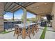 Inviting outdoor dining area with a full kitchen, bar seating, and modern pergola shading a large table set at 6690 Interstellar St, Las Vegas, NV 89135