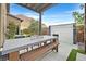 Stylish outdoor dining area with a large table, bench seating, and soothing water feature at 6690 Interstellar St, Las Vegas, NV 89135