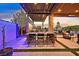 Covered outdoor dining area with a table, chairs, BBQ, and a built-in kitchen overlooking the stunning pool and beautiful outdoor sunset at 6690 Interstellar St, Las Vegas, NV 89135