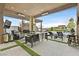 Expansive covered patio with multiple seating areas, outdoor kitchen, and a serene backyard view at 6690 Interstellar St, Las Vegas, NV 89135