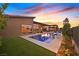 Stunning backyard oasis with a sparkling pool, built-in loungers, lush landscaping, and an outdoor kitchen, perfect for entertaining at 6690 Interstellar St, Las Vegas, NV 89135