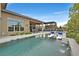 Backyard swimming pool with a spa and in-pool lounge chairs and an outdoor kitchen with mountain views at 6690 Interstellar St, Las Vegas, NV 89135