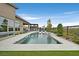 Backyard pool featuring a spa with in-pool loungers, lush landscaping, and a mountain view backdrop at 6690 Interstellar St, Las Vegas, NV 89135