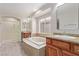 Bathroom showcasing dual vanity, a soaking tub with tile surround, and glass-enclosed shower at 6712 Biltmore Garden St, Las Vegas, NV 89149