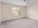 Cozy carpeted bedroom with a ceiling fan and ample natural light from the large window at 6712 Biltmore Garden St, Las Vegas, NV 89149
