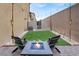 Cozy backyard with artificial turf, decorative lighting, and comfortable seating around a fire pit at 7305 Halo Falls St, North Las Vegas, NV 89084