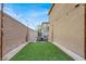 Enclosed backyard with artificial grass, string lights, and comfortable seating area for outdoor enjoyment at 7305 Halo Falls St, North Las Vegas, NV 89084
