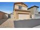 Tan two-story home featuring attached two car garage and low maintenance desert landscaping at 7305 Halo Falls St, North Las Vegas, NV 89084