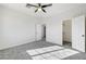 An open and airy bedroom featuring new gray carpet, ceiling fan, and two closets at 7900 Holly Knoll Ave, Las Vegas, NV 89129
