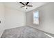 Well-lit bedroom featuring plush gray carpeting, ceiling fan, and large window at 7900 Holly Knoll Ave, Las Vegas, NV 89129