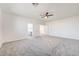 Spacious bedroom featuring a ceiling fan, plush carpet and access to the connected bathroom and hallway at 7900 Holly Knoll Ave, Las Vegas, NV 89129