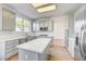 Well-lit kitchen boasts a central island, stainless appliances, and gray cabinets at 7900 Holly Knoll Ave, Las Vegas, NV 89129