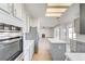 Modern kitchen with stainless appliances, an island, tile backsplash, and open views of the living area at 7900 Holly Knoll Ave, Las Vegas, NV 89129