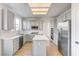 This kitchen features an island, stainless steel appliances, quartz countertops and a window at 7900 Holly Knoll Ave, Las Vegas, NV 89129