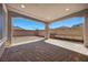 Covered patio with a brick floor and a spacious backyard with benches and a wood rack at 8106 Skye Glen St, Las Vegas, NV 89166