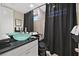 Bathroom with blue glass bowl sink, black countertop, and black shower curtain at 8390 Carmel Ridge Ct, Las Vegas, NV 89113