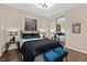 Bedroom features wood floors, modern lighting, a window with curtains, and decorative wall art at 8390 Carmel Ridge Ct, Las Vegas, NV 89113