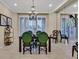 Elegant dining room features a dark wood table with green upholstered chairs and a decorative chandelier at 8390 Carmel Ridge Ct, Las Vegas, NV 89113