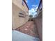 Backyard of a home showing rock and concrete landscaping with a walkway to a black fence at 8576 Peaceful Dreams St, Las Vegas, NV 89139