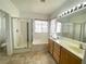 Bright bathroom featuring double vanity, shower, soaking tub, and tile flooring at 8576 Peaceful Dreams St, Las Vegas, NV 89139