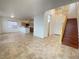 Spacious living room with tile flooring, open to the kitchen and featuring a grand staircase at 8576 Peaceful Dreams St, Las Vegas, NV 89139