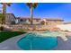 An in-ground backyard pool surrounded by lush green grass, a palm tree, and privacy walls at 9020 Loggers Mill Ave, Las Vegas, NV 89143