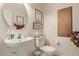 Powder room features a pedestal sink, toilet, and decorative accents at 9020 Loggers Mill Ave, Las Vegas, NV 89143
