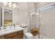 This bathroom features a vanity, toilet, and walk-in shower with tiled walls, a glass door and built-in wood bench at 9930 Zakos Ct, Las Vegas, NV 89149