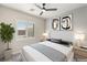 This staged bedroom has a bed with decorative pillows, a ceiling fan, and a shuttered window at 9930 Zakos Ct, Las Vegas, NV 89149