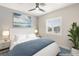 This staged bedroom has a shuttered window for natural light, a ceiling fan, and a leafy plant at 9930 Zakos Ct, Las Vegas, NV 89149