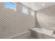 This main bathroom features decorative tile wall in the shower and soaking tub area and three clerestory windows at 9930 Zakos Ct, Las Vegas, NV 89149