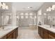 This main bathroom features double sinks with dark wood cabinetry, as well as a soaking tub and tiled walk-in shower at 9930 Zakos Ct, Las Vegas, NV 89149