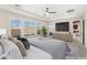 This staged main bedroom features recessed lighting, a ceiling fan, outside views and an adjacent bathroom and closet at 9930 Zakos Ct, Las Vegas, NV 89149