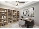 This staged office area has a shelving unit and a desk with a contemporary styled lamp and painting at 9930 Zakos Ct, Las Vegas, NV 89149