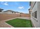 Backyard featuring artificial turf, privacy wall, and stone landscaping at 9983 Cluny Ave, Las Vegas, NV 89178