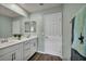 This bathroom offers a dual vanity with white cabinets, modern fixtures, and wood-look flooring at 9983 Cluny Ave, Las Vegas, NV 89178