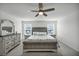 Bedroom featuring neutral tones, ceiling fan, and a large decorative mirror at 9983 Cluny Ave, Las Vegas, NV 89178
