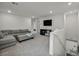 Spacious living room with a grey sectional sofa, neutral walls, and recessed lighting at 9983 Cluny Ave, Las Vegas, NV 89178