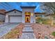 Exterior shot showing a home's entrance with desert landscaping, a paver walkway, and accent lighting at 101 Mirage View Dr, Henderson, NV 89011