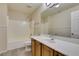 Bathroom with wood cabinets, and shower over tub with grey wood look floors at 10311 Birch Bluff Ln, Las Vegas, NV 89145