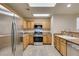 Bright kitchen featuring stainless steel appliances, tile floors, and wood cabinets at 10311 Birch Bluff Ln, Las Vegas, NV 89145