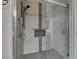 Tiled shower with glass door, shower caddy, and shower head at 10311 Birch Bluff Ln, Las Vegas, NV 89145