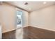 Bright bedroom with dark wood floors, sliding glass doors to an outdoor space, and neutral wall color at 10476 Tyler Park Ave, Las Vegas, NV 89135