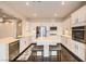 Bright kitchen featuring white cabinets, stainless steel appliances, island with marble countertop and dark wood floors at 10476 Tyler Park Ave, Las Vegas, NV 89135