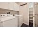 Well-equipped laundry room with modern washer and dryer, plus convenient built-in shelving at 10476 Tyler Park Ave, Las Vegas, NV 89135